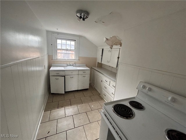 kitchen featuring white cabinets, light tile patterned floors, lofted ceiling, white range with electric stovetop, and sink