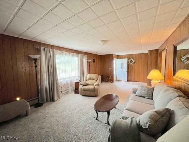 carpeted living room featuring wooden walls