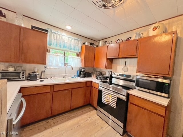 kitchen with light hardwood / wood-style flooring, stainless steel appliances, and sink