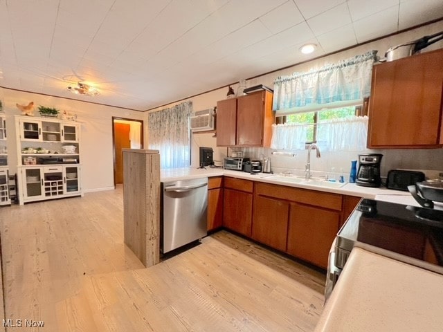 kitchen with sink, tasteful backsplash, light hardwood / wood-style flooring, dishwasher, and a wall mounted air conditioner