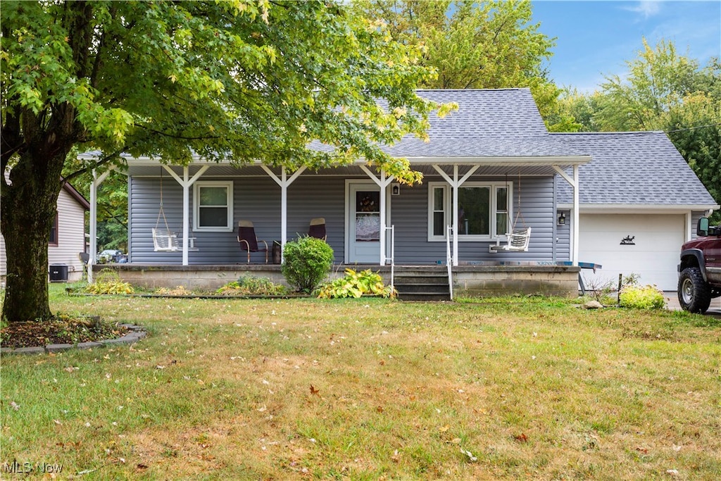 ranch-style house featuring a garage, a porch, a front lawn, and central air condition unit