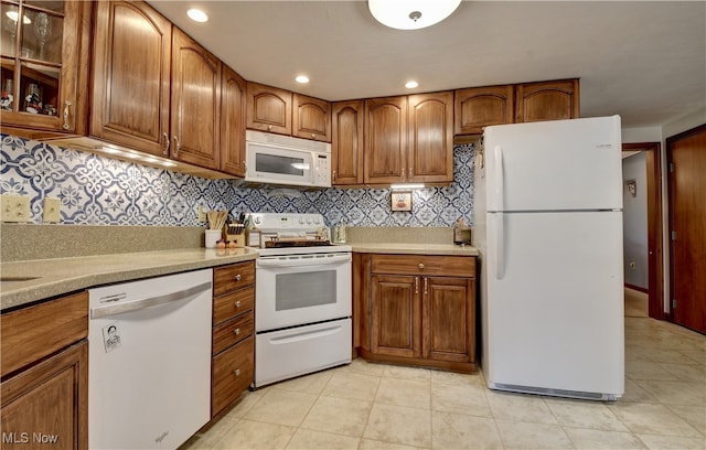 kitchen with white appliances, light tile patterned flooring, and backsplash