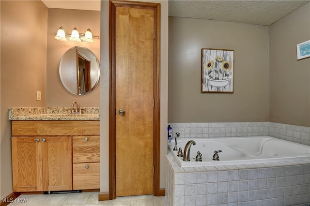 bathroom featuring tiled tub, vanity, a textured ceiling, and tile patterned floors