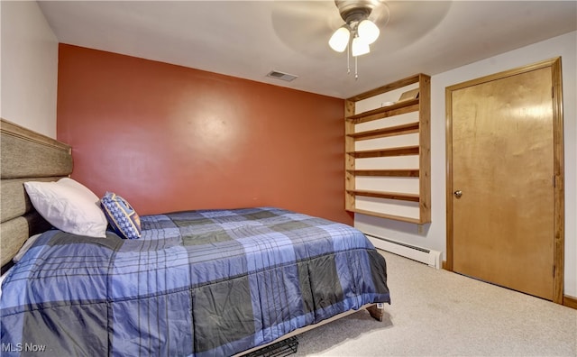 carpeted bedroom with ceiling fan and a baseboard heating unit