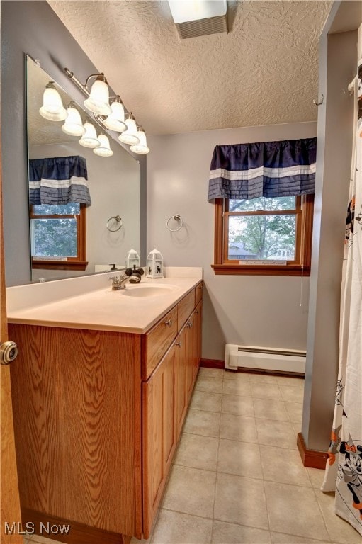 bathroom with vanity, baseboard heating, a textured ceiling, walk in shower, and tile patterned floors