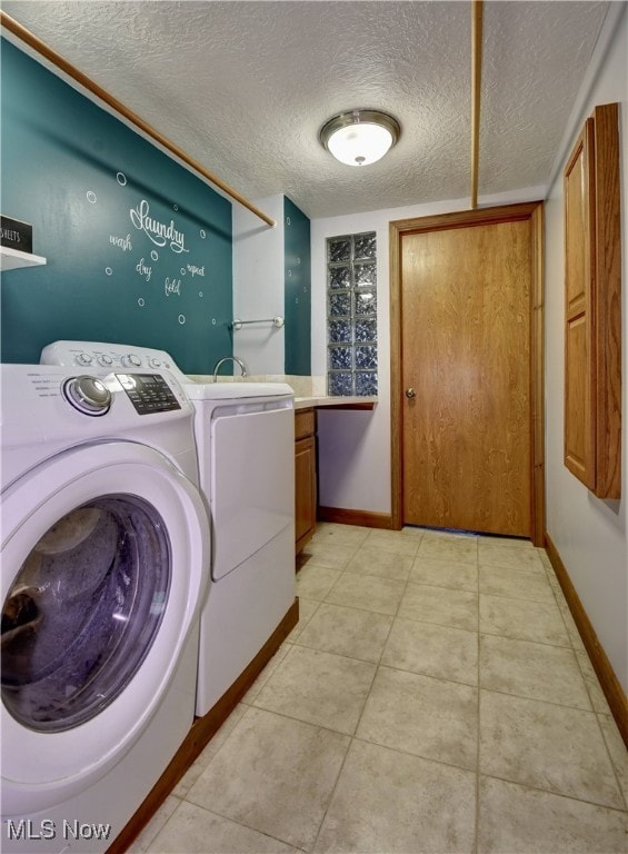 washroom with cabinets, light tile patterned floors, a textured ceiling, and independent washer and dryer