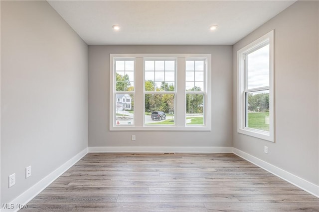 unfurnished room featuring plenty of natural light and light hardwood / wood-style floors