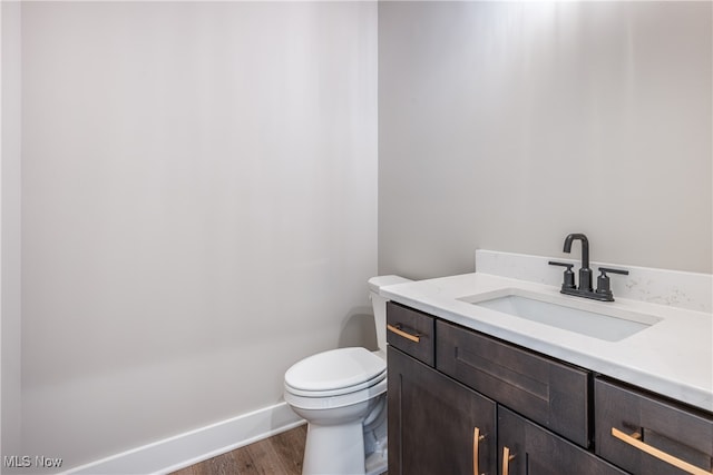 bathroom featuring hardwood / wood-style flooring, vanity, and toilet