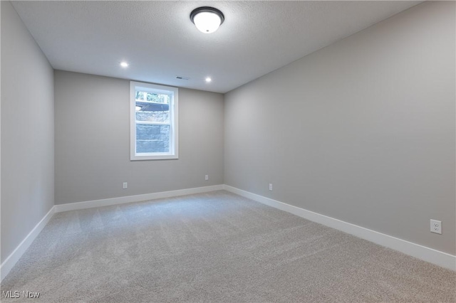 spare room with a textured ceiling and carpet