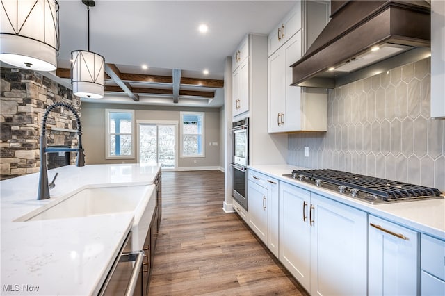 kitchen featuring stainless steel appliances, hardwood / wood-style floors, beam ceiling, and white cabinetry