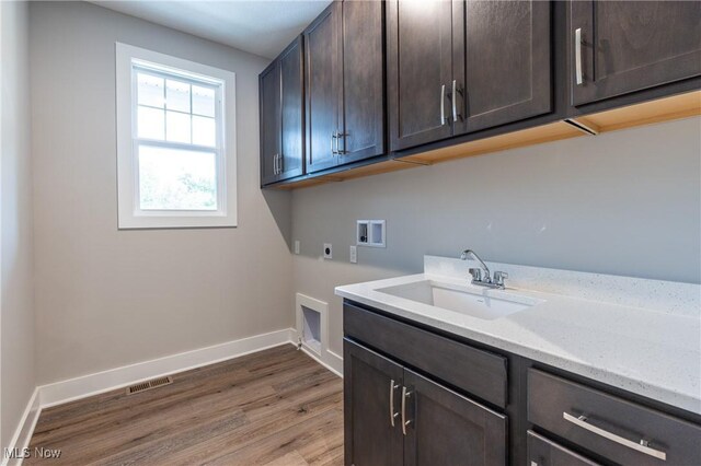 washroom with washer hookup, sink, cabinets, dark hardwood / wood-style flooring, and electric dryer hookup