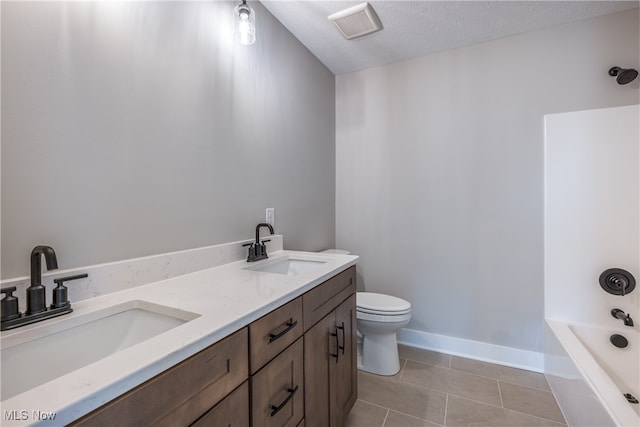 full bathroom featuring vanity, bathtub / shower combination, tile patterned flooring, toilet, and a textured ceiling