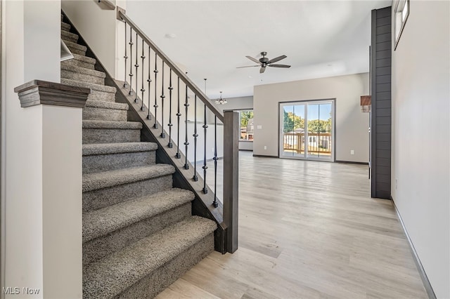 stairs with ceiling fan and hardwood / wood-style floors