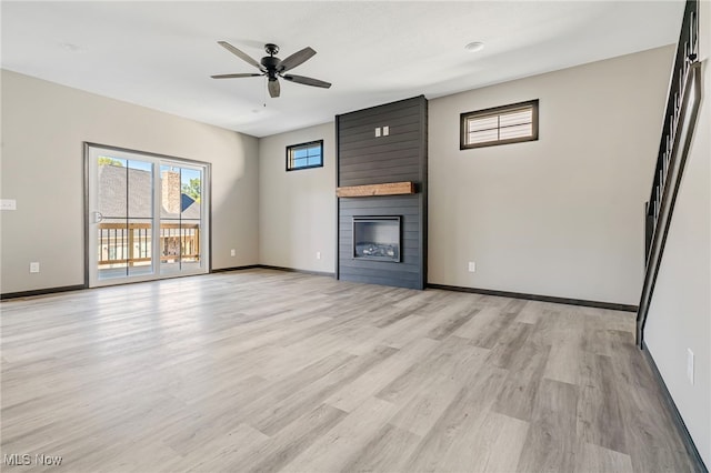 unfurnished living room with ceiling fan, a fireplace, and light hardwood / wood-style floors