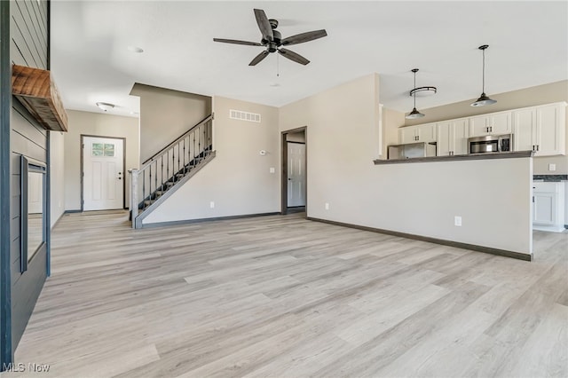 unfurnished living room featuring ceiling fan and light hardwood / wood-style flooring