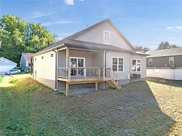 back of property with cooling unit, a yard, and a wooden deck