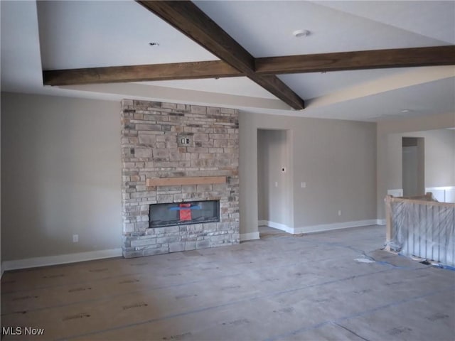 unfurnished living room featuring a stone fireplace, hardwood / wood-style floors, and beamed ceiling