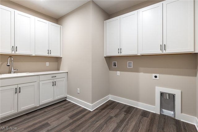 laundry area featuring a sink, baseboards, cabinet space, dark wood finished floors, and electric dryer hookup