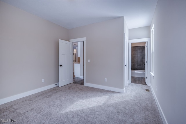 unfurnished bedroom featuring carpet, visible vents, and baseboards