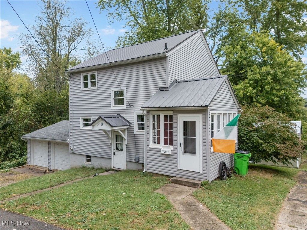 rear view of house featuring a garage and a yard