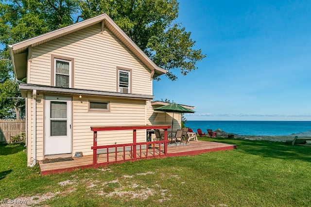 rear view of house featuring a lawn and a water view