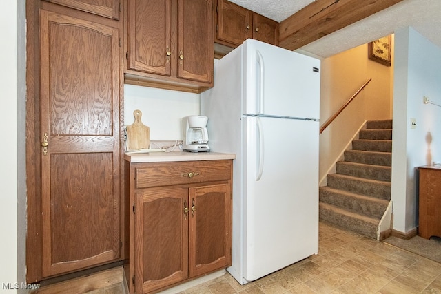 kitchen with a textured ceiling and white fridge