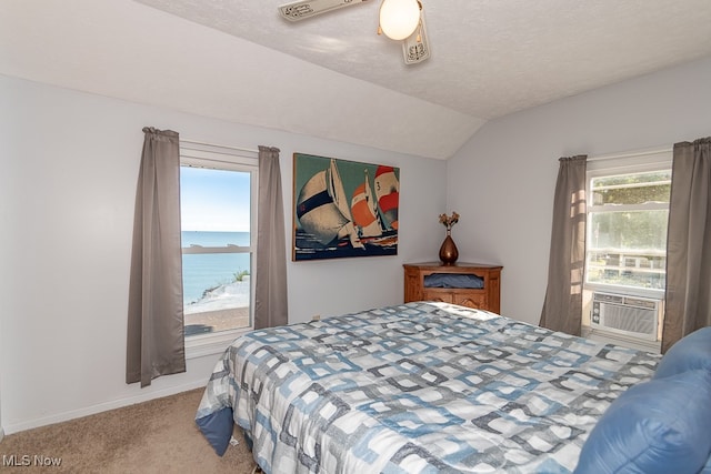 bedroom featuring ceiling fan, carpet flooring, a textured ceiling, vaulted ceiling, and a water view