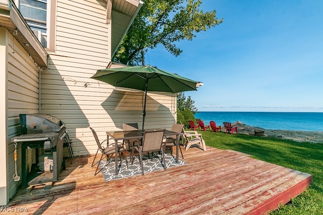 deck with a water view, a yard, and a grill