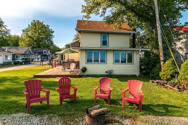 rear view of property featuring a lawn and a wooden deck