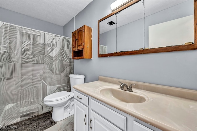 bathroom with vanity, toilet, and a textured ceiling