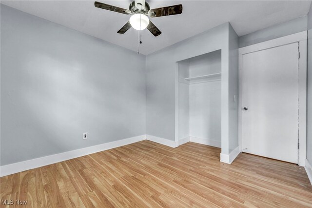 unfurnished bedroom featuring light hardwood / wood-style flooring, ceiling fan, and a closet