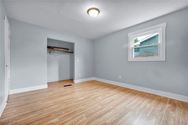 unfurnished bedroom featuring a closet and light hardwood / wood-style flooring