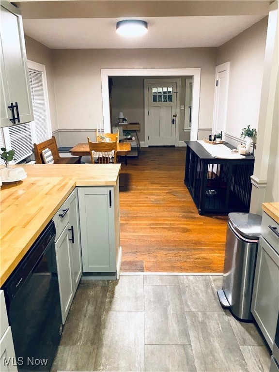 kitchen featuring light wood-type flooring, black dishwasher, and wooden counters