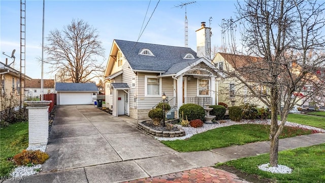 bungalow-style home with a garage, an outbuilding, and a front yard