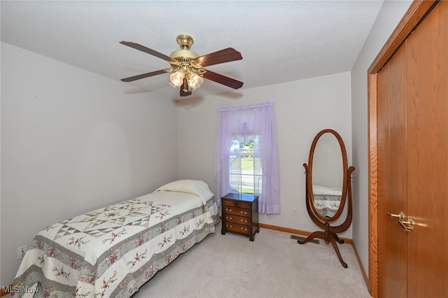 bedroom featuring ceiling fan, a closet, and light carpet