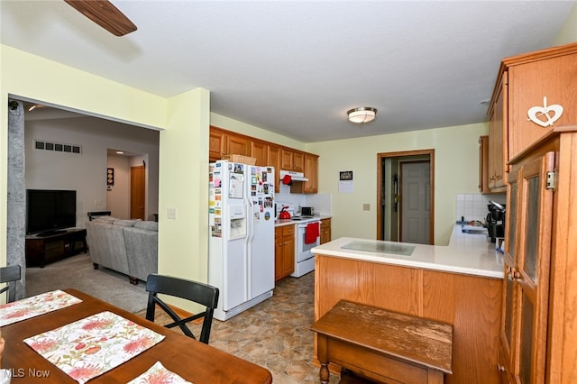 kitchen with a textured ceiling, kitchen peninsula, white appliances, backsplash, and ceiling fan