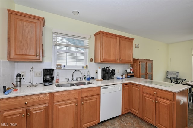 kitchen with dishwasher, sink, kitchen peninsula, and decorative backsplash