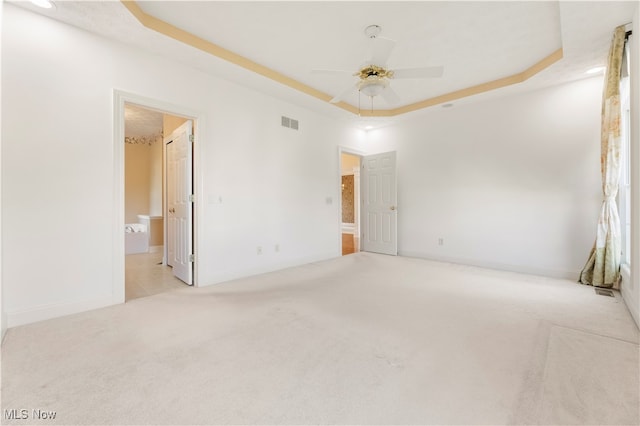 carpeted empty room featuring ceiling fan and a tray ceiling