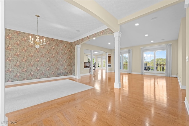 interior space featuring beamed ceiling, light hardwood / wood-style flooring, decorative columns, ornamental molding, and a notable chandelier