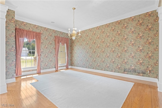 unfurnished room with wood-type flooring, ornamental molding, and a chandelier