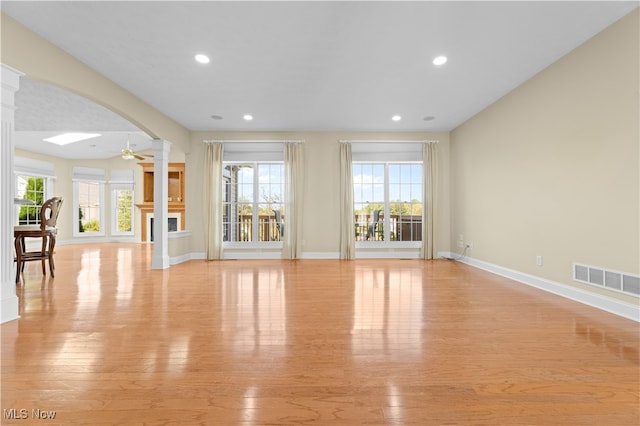 unfurnished living room featuring a wealth of natural light, light hardwood / wood-style floors, and ceiling fan