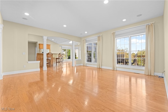 unfurnished living room with light hardwood / wood-style floors and decorative columns