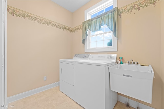 clothes washing area featuring separate washer and dryer and sink