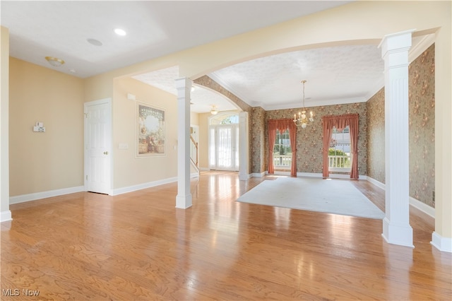 interior space featuring plenty of natural light, a chandelier, light hardwood / wood-style flooring, and ornate columns