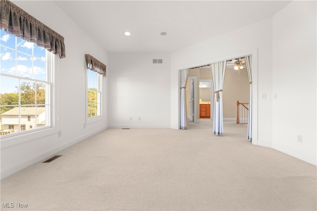 spare room with ceiling fan and light colored carpet