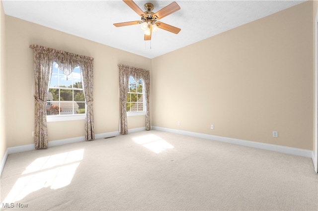 empty room featuring ceiling fan and light colored carpet