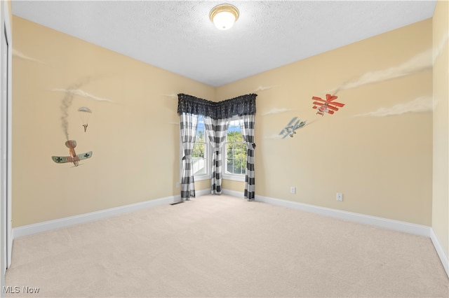 carpeted empty room with a textured ceiling