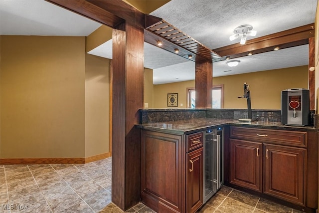 kitchen featuring beverage cooler, a textured ceiling, and vaulted ceiling