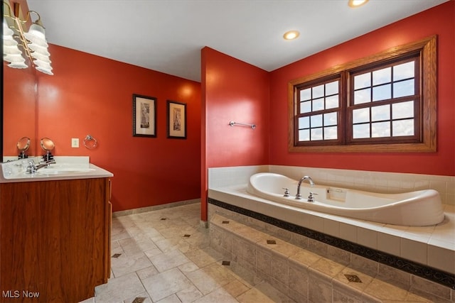 bathroom with vanity and a relaxing tiled tub