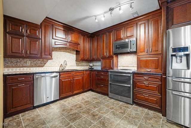 kitchen with decorative backsplash, appliances with stainless steel finishes, and sink